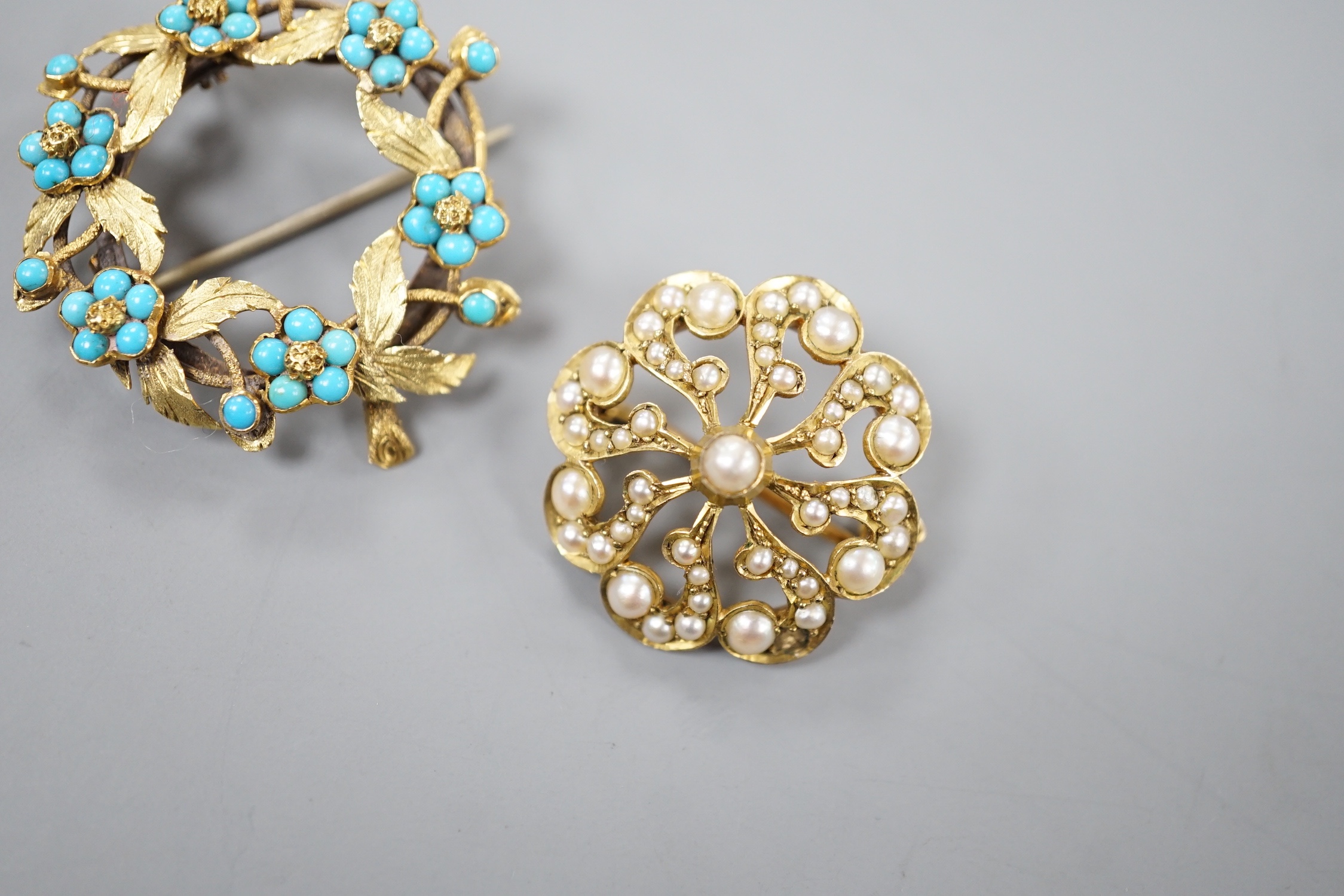 An Edwardian 9ct and seed pearl set brooch, 23mm and a yellow metal and turquoise set wreath brooch, gross 9.3 grams